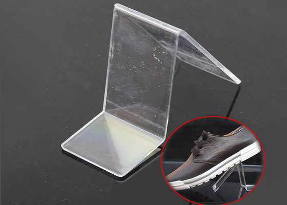 L'adulte chausse le présentoir acrylique de vente au détail de magasin de chaussure de présentoirs de canalisation verticale